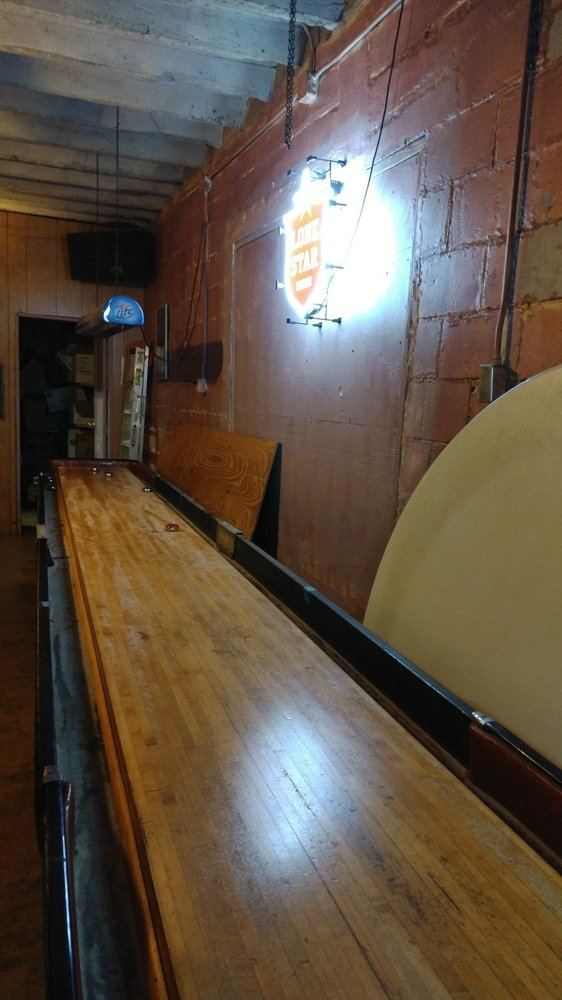 The long wooden shuffleboard table
